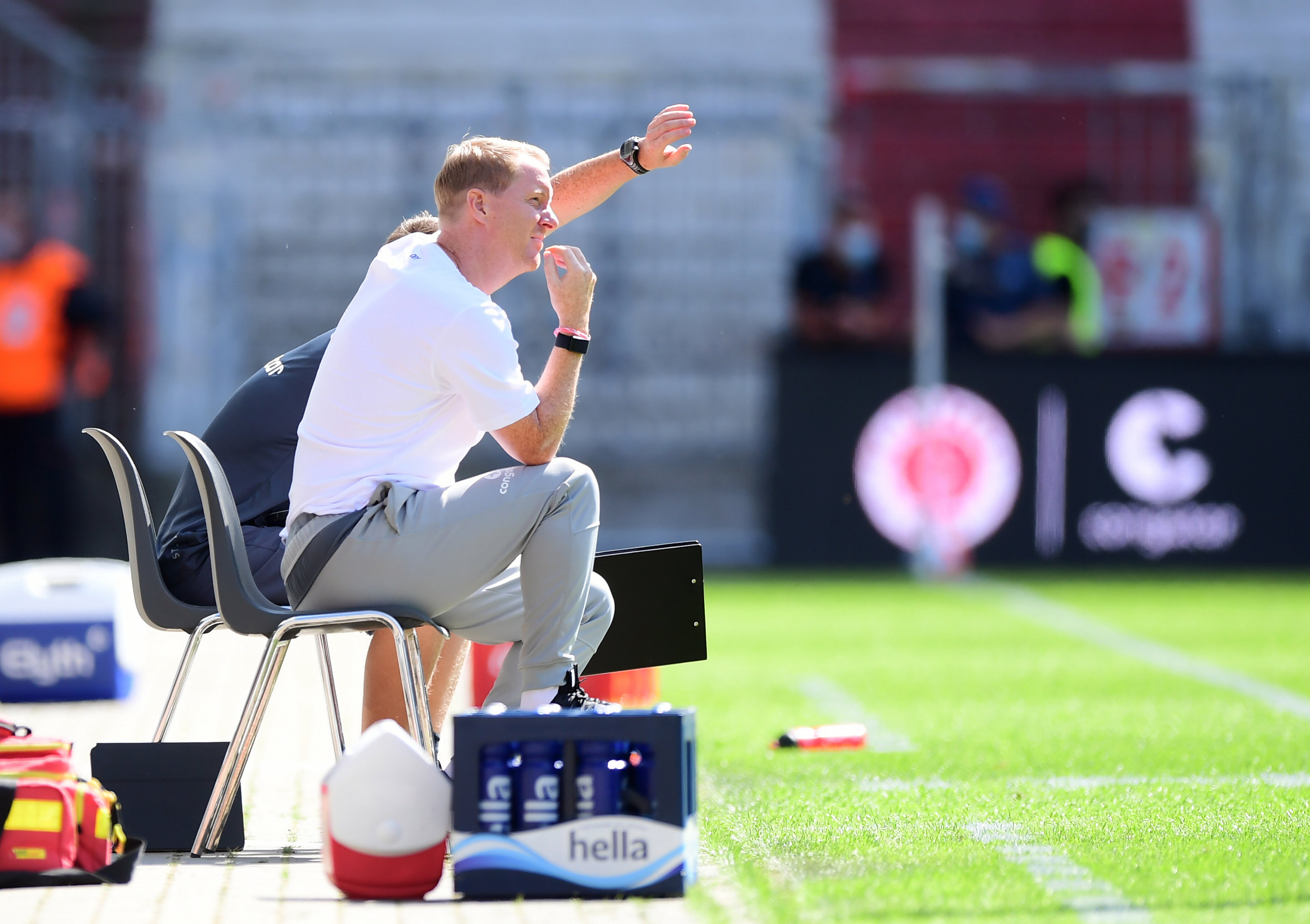 Timo Schultz sitzt auf dem Stuhl an der Seitenlinie des Spielfeldes am Millerntor-Stadion.