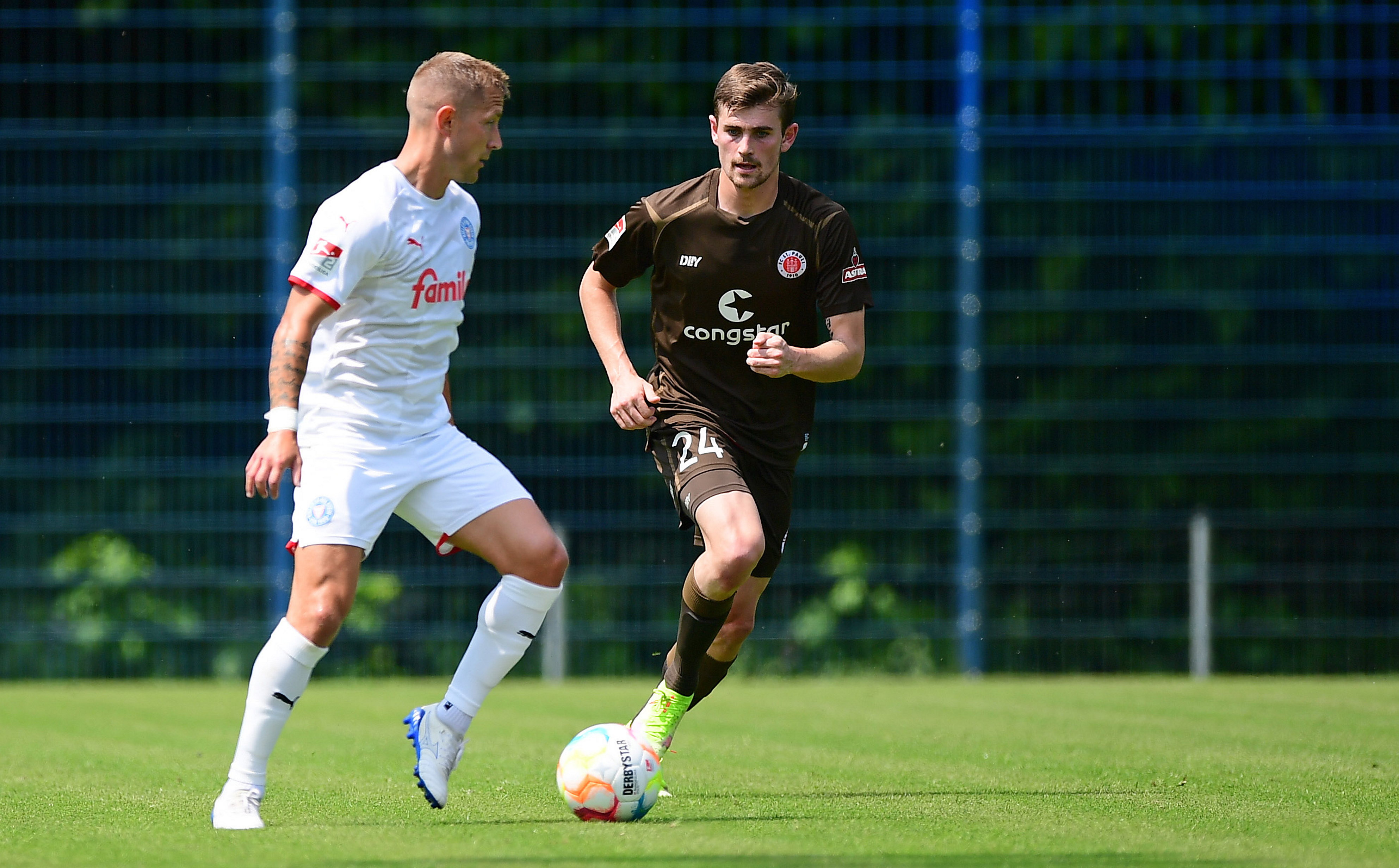 Connor Metcalfe (right) about to go up against Kiel's Lewis Holtby.