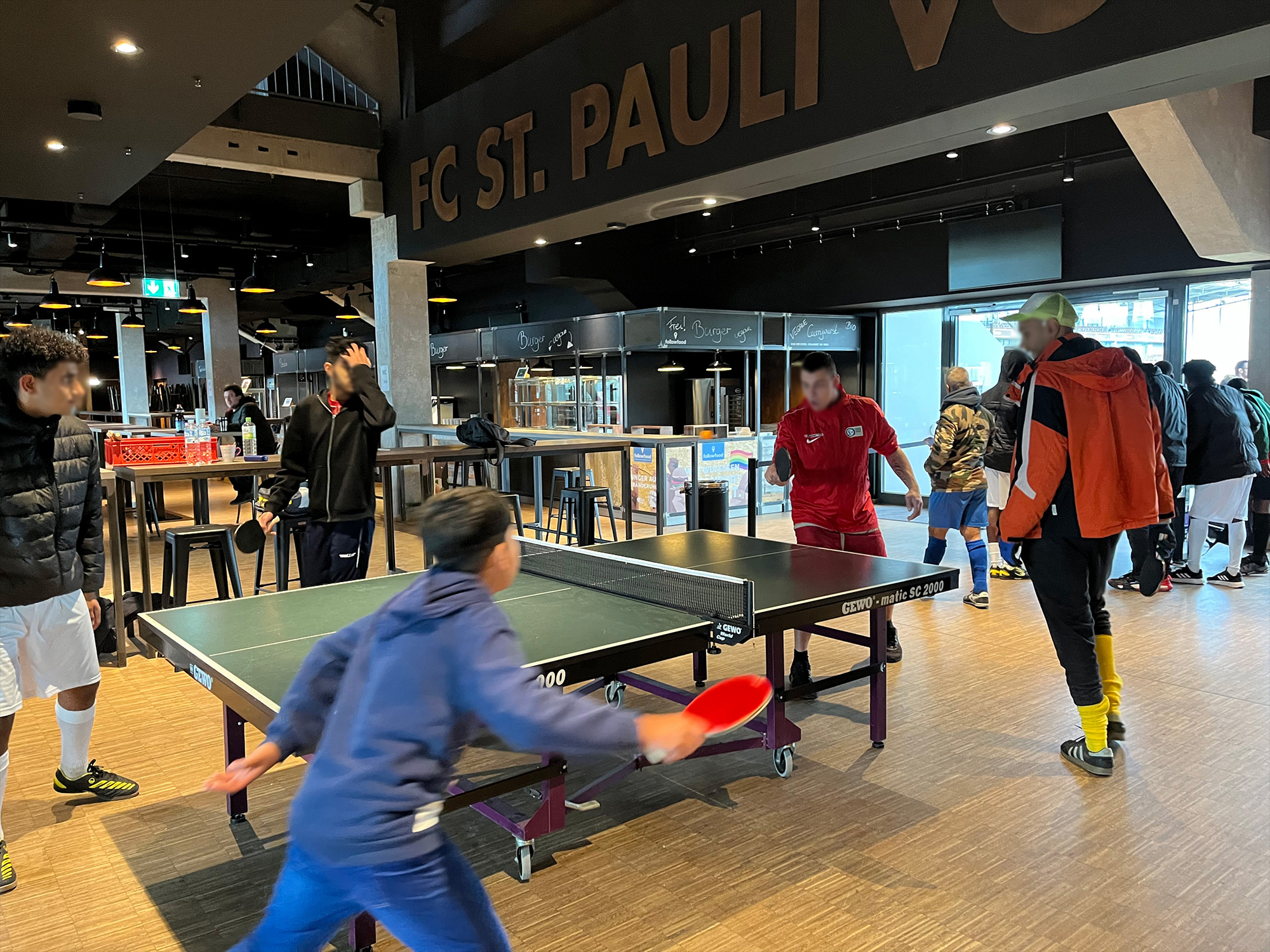 Teilnehmer der Straßenfußball-DM spielen im Ballsaal der Südtribüne Tischtennis.