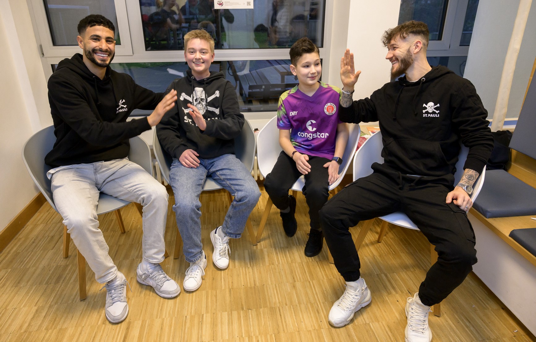 Elias Saad (li) und Marcel Hartel (re.) nahmen sich viel Zeit für die Patient*innen, unter ihnen auch einige FCSP-Fans.