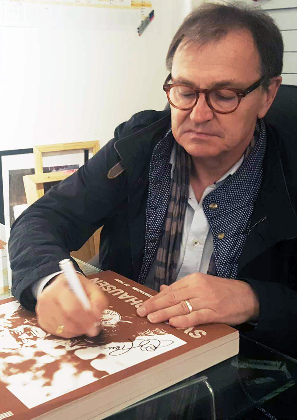 Ewald Lienen signiert die Kunstdrucke.