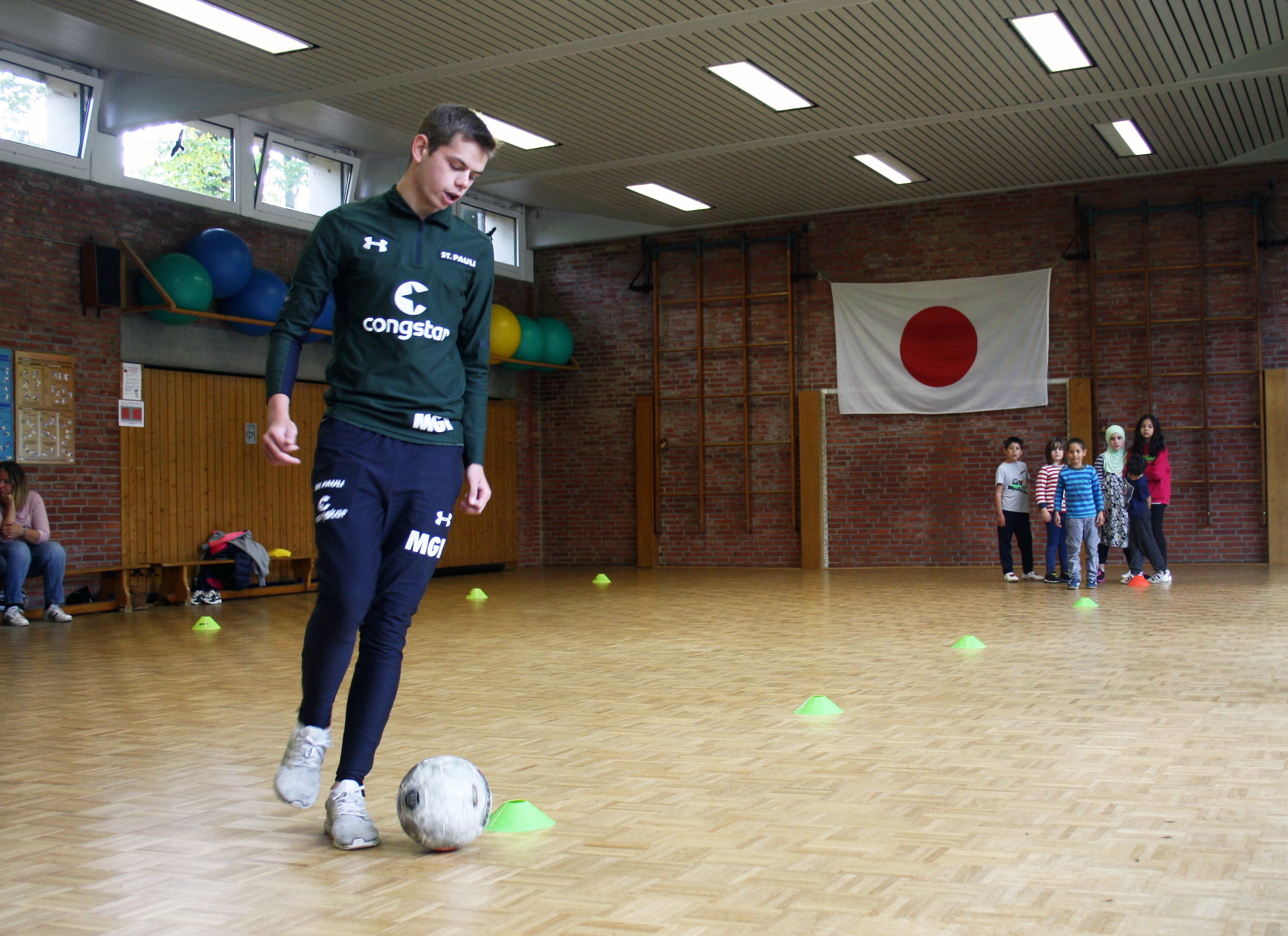 FCSP-Rabauken-Trainer Max macht die Übung vor, die Kinder schauen gespannt zu.