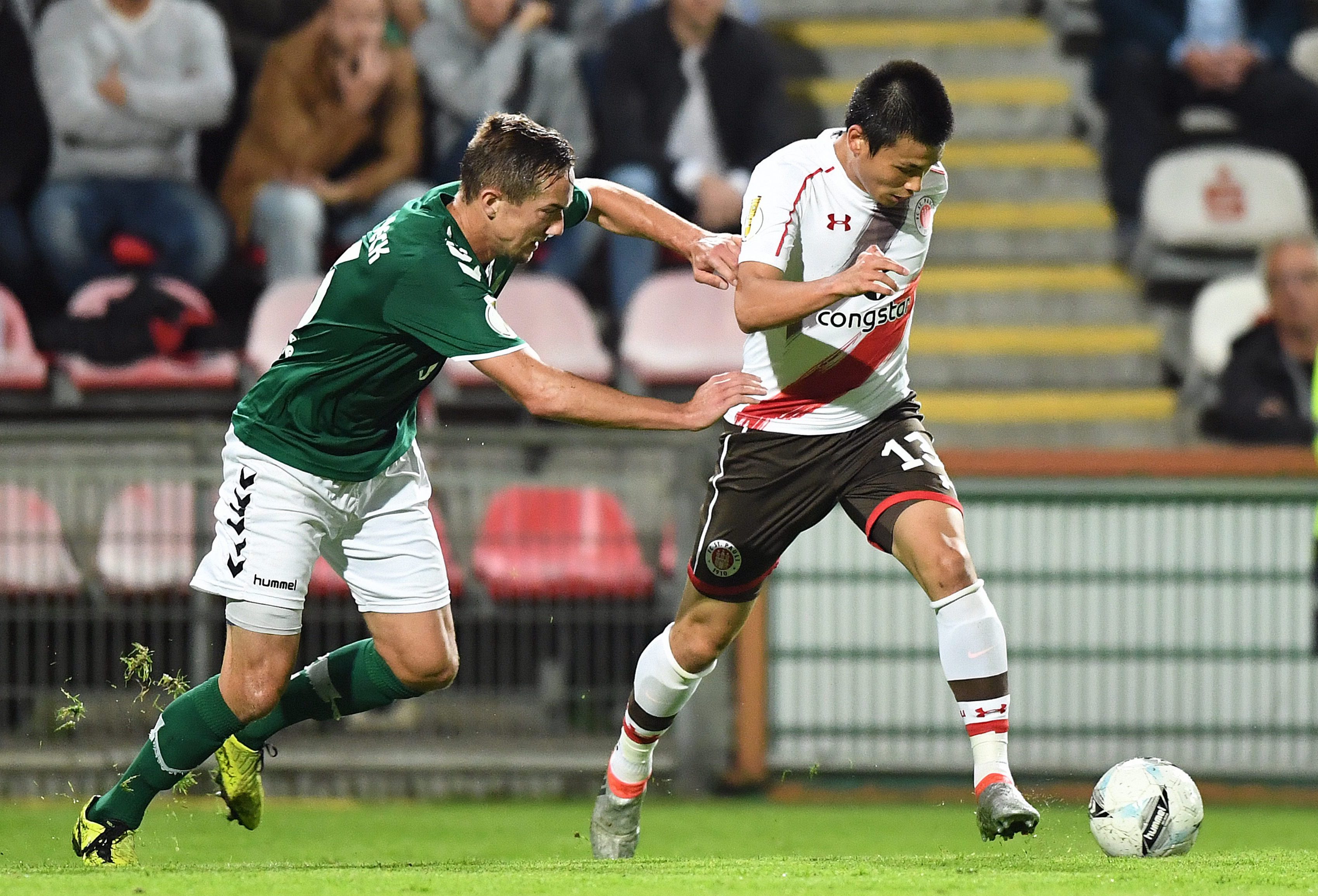 Ryo Miyaichi is challenged by Lübeck's Enes Dagli in 2016.