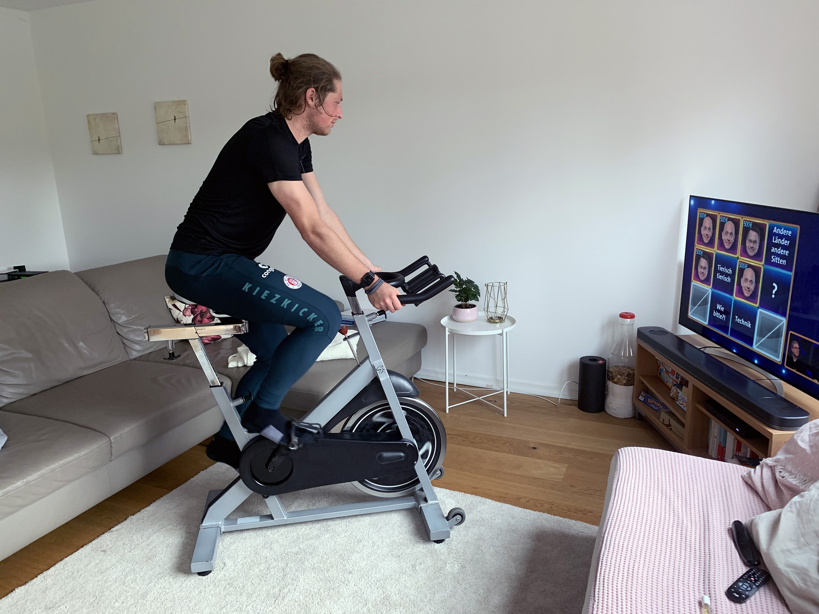 Home-Office-Training á la Buballa. Der Abwehrspieler tritt vor dem Fernseher in die Pedale.