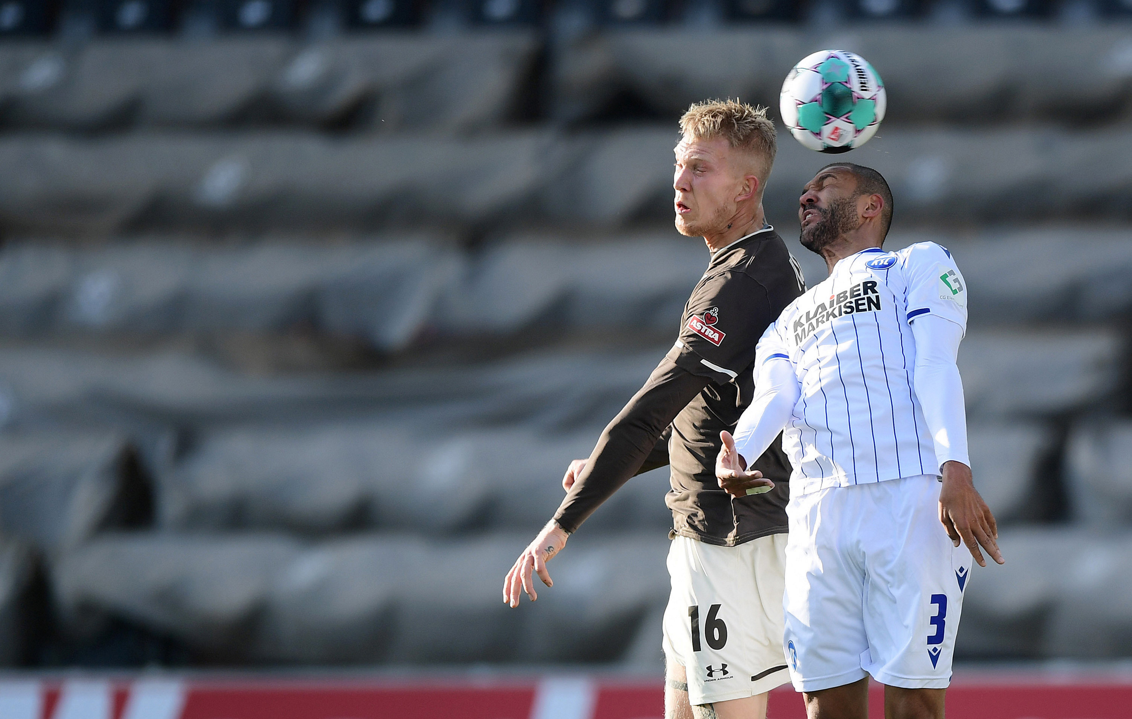 Simon Makienok in an aerial challenge with Karlsruhe's Daniel Gordon.